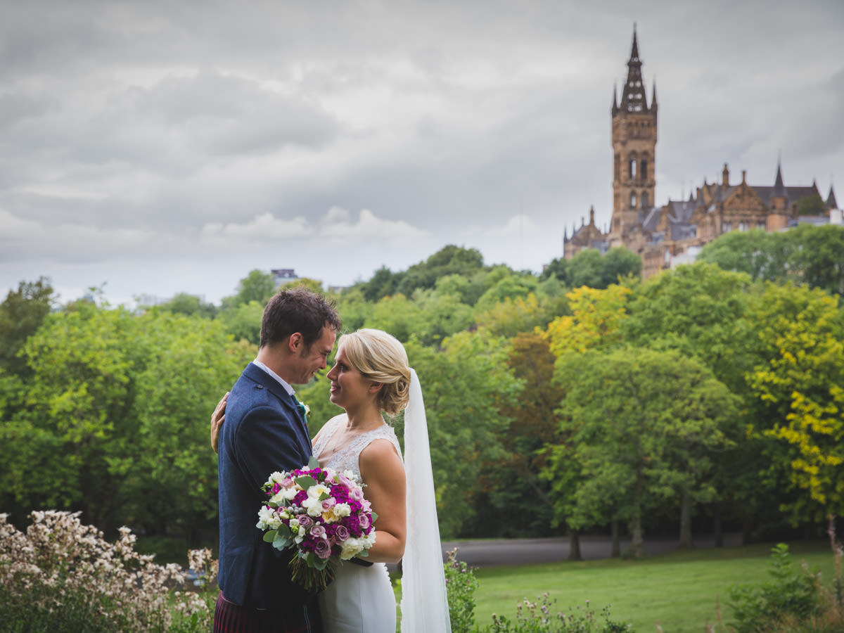 Glasgow University. Bride and groom on their wedding day in Kelvingrove Park overlooking Glasgow University.